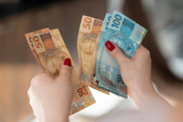 frau hand hält eine währung von reais, brasilianische geld - cash box stock-fotos und bilder