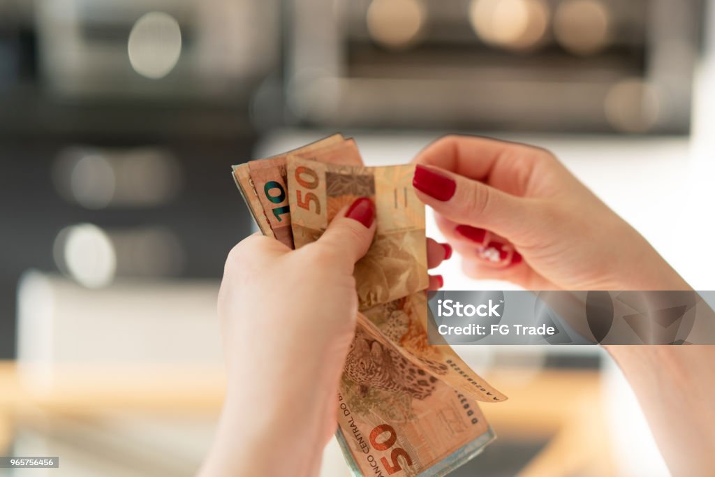 Woman hand holding a the currency of reais, brazilian money Counting my money Paper Currency Stock Photo