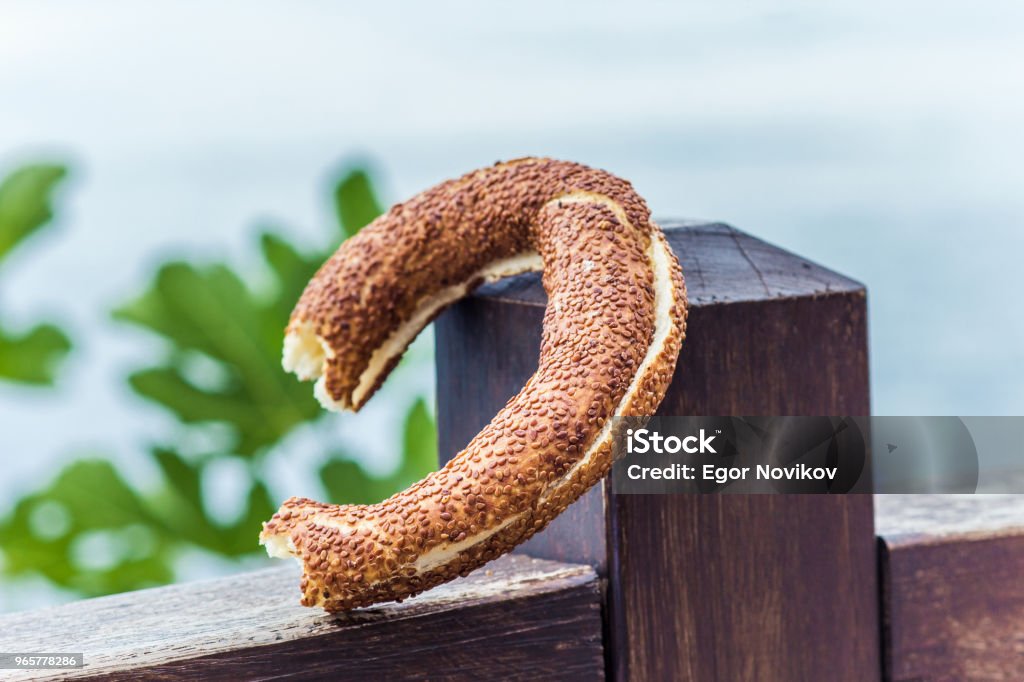 one Turkish bagel (simit) laid on a wooden surface, close-up one Turkish bagel (simite) laid on a wooden surface, close-up Bagel Stock Photo