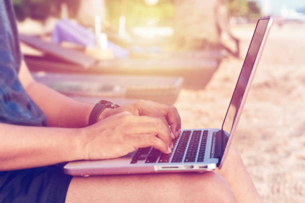 istock A man wearing shorts with laptop working on a summer day on the beach 965792832