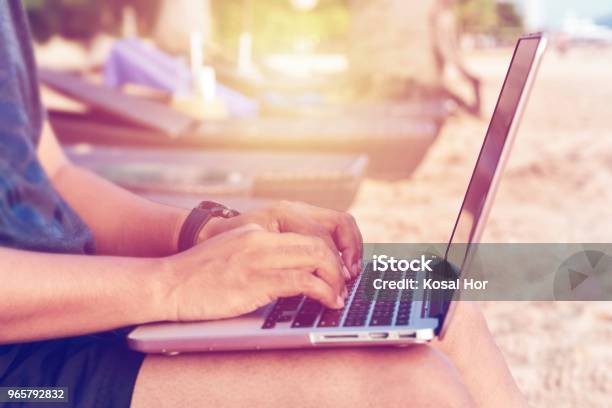 A Man Wearing Shorts With Laptop Working On A Summer Day On The Beach Stock Photo - Download Image Now