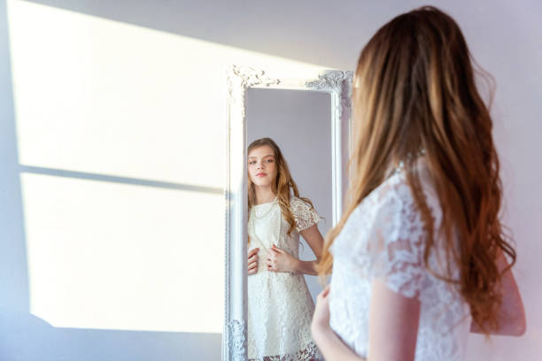 istock Young girl looking in mirror 965820340
