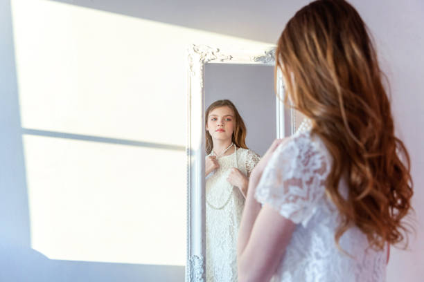 istock Young girl looking in mirror 965820486