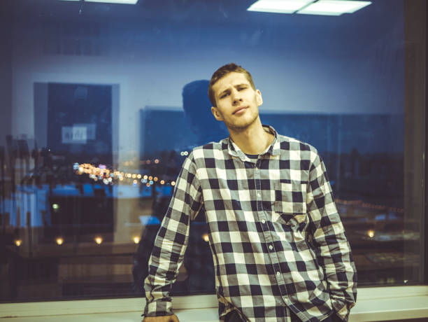 istock man in shirt standing near the window with reflection 965846754