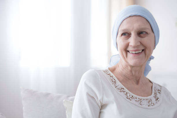 Happy and hopeful cancer patient Upper body portrait of an older, female cancer patient looking happy and hopeful in a bright white interior bare bosom pic stock pictures, royalty-free photos & images