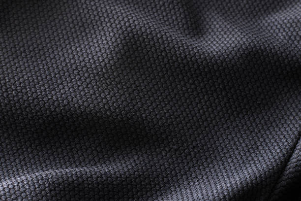 Close-up polyester fabric texture of black athletic shirt Close-up polyester fabric texture of black athletic shirt with ambient light jersey fabric photos stock pictures, royalty-free photos & images