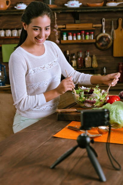 здоровое питание - испаноязычные блоггер женщина делает веганский салат с органическими ингредиентами в деревенской кухне - fruit salad fruit healthy eating making стоковые фото и изображения