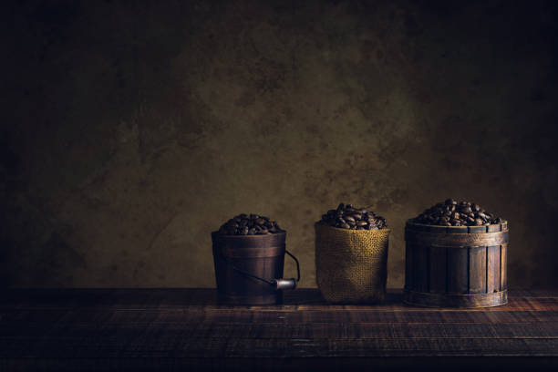 coffee beans in container on wood floor and old paper vintage aged background or texture