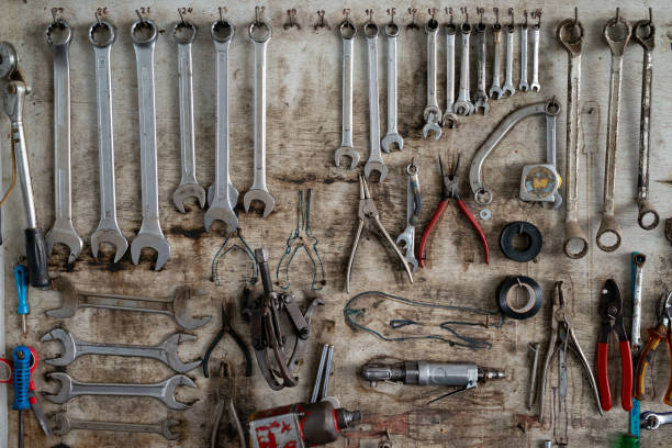 istock Wrench in various sizes hanging on wood background, Tool shelf against a table and wall 965959998