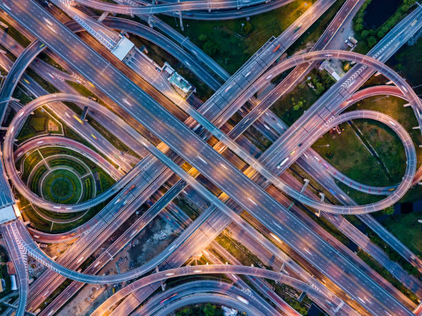 vista dall'alto degli svincoli stradali autostradali di notte. la strada autostradale intersecting supera la tangenziale esterna orientale di bangkok, thailandia. - mischiare foto e immagini stock