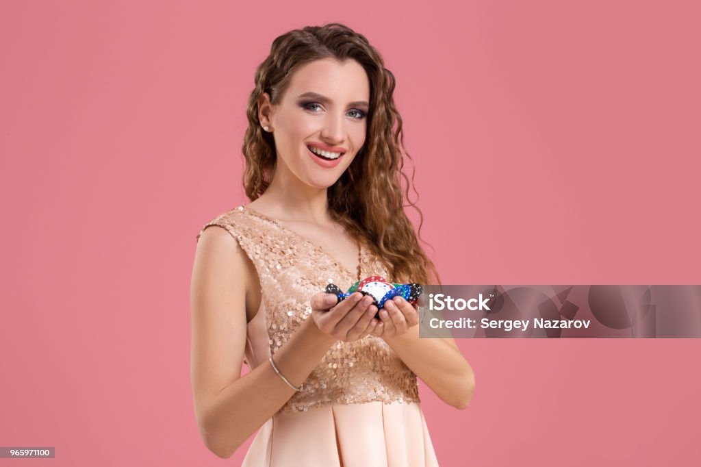 Lächelndes Mädchen hält ein Glücksspiel Chips in ihrem Nands auf rosa Hintergrund - Lizenzfrei Erfolg Stock-Foto