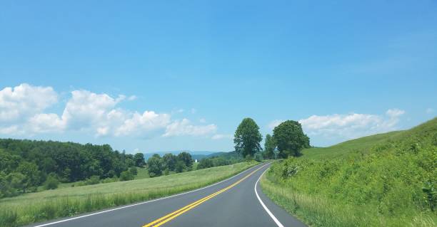 istock asphalt road with green grass and hills 965997712