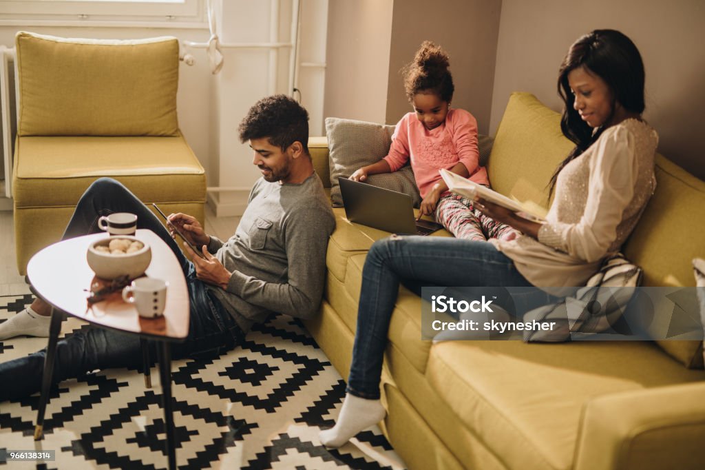 Lächelnde afroamerikanische Familie verbringt ihre freie Zeit zu Hause. - Lizenzfrei Familie Stock-Foto