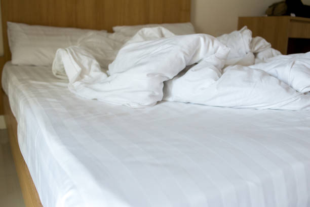 istock white blanket dishevelled on the bed 966149156