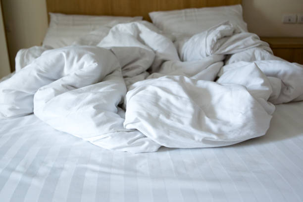 istock white blanket dishevelled on the bed 966150414