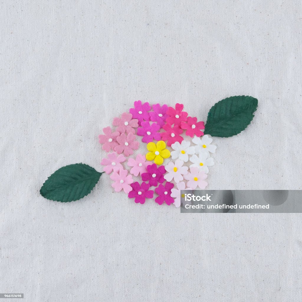 Fiori di carta tono rosa e bouquet di foglie verdi su tessuto mussola - Foto stock royalty-free di Amore