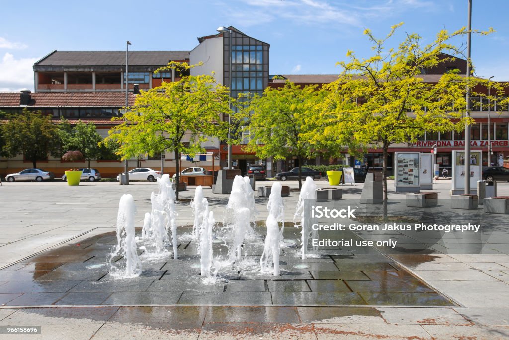 Water fountain in Zupanja Zupanja, Croatia - May 15, 2018 : A view of the water fountain on the town square in Zupanja, Croatia. Bench Stock Photo