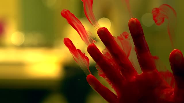 Silhouette scared girl hand with red blood behind a glass door, horror background.
