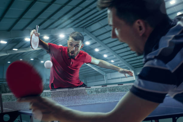 the young sports men tennis players in play on black arena background with lights - table tennis imagens e fotografias de stock