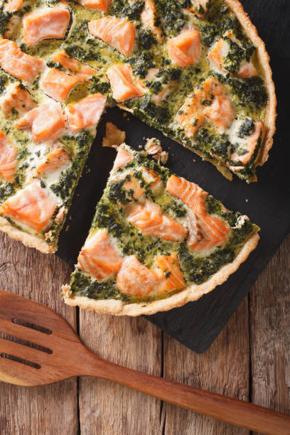 istock Tasty sliced Savory quiche with salmon and spinach, close-up. vertical top view 966183840