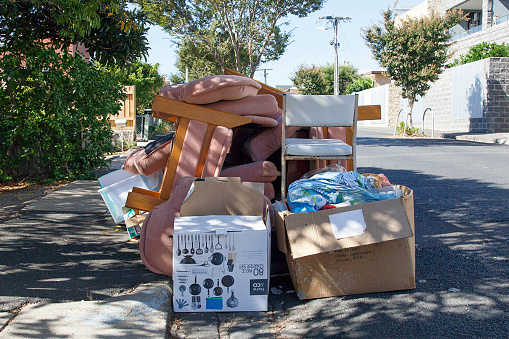 St Kilda, Australia: March 04, 2018: A sofa and other household items are dumped in a middle class residential housing area. The continuing problem of illegal dumping of household items has resulted in frequent prosecutions of fly tippers who are unwilling to pay depot dumping fees.