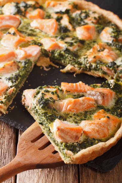 istock Sliced Quiche with salmon, spinach and cream close-up. vertical 966188788