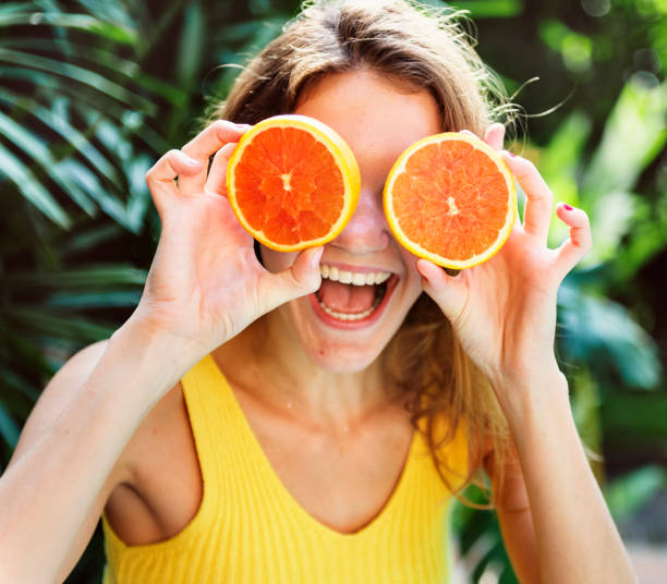 istock Happy young woman with oranges 966188858
