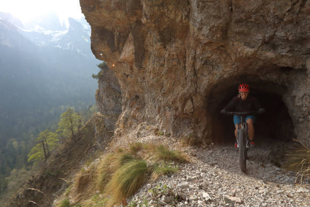 istock Mountain biker exits tunnel on high mountain trail, South Tyrol 966189982
