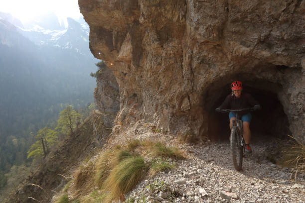 istock Mountain biker exits tunnel on high mountain trail, South Tyrol 966190152