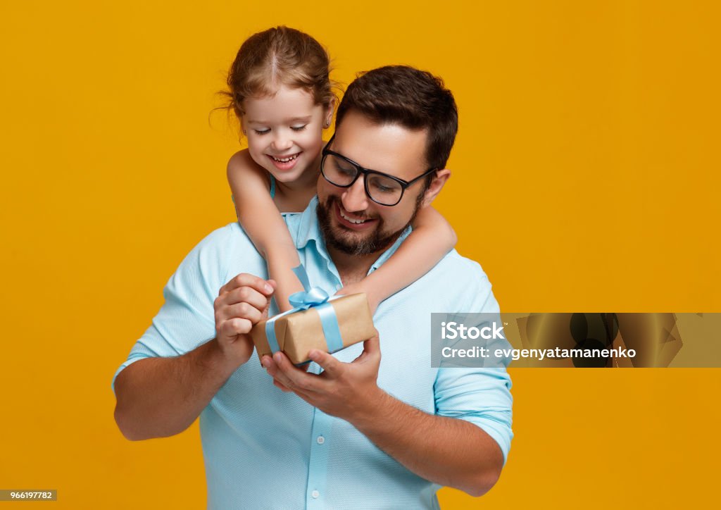 happy father's day! cute dad and daughter hugging on yellow background happy father's day! cute dad and daughter hugging on colored yellow background Gift Stock Photo