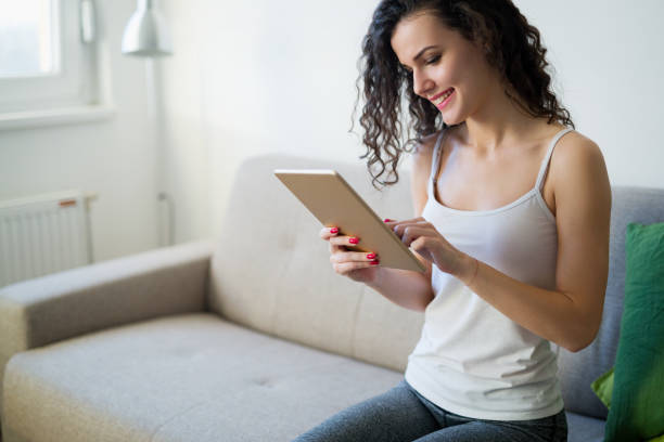 istock Beautiful woman at home working with tablet 966200074
