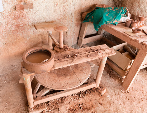 Primitive wooden pottery and red clay are the tools of an ancient artisan