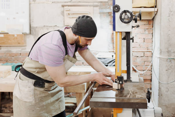 istock profession, carpentry, woodwork and people concept - carpenter working with plane and wood plank at workshop 966210518