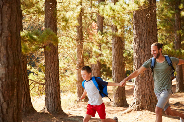 istock Father And Son On Hiking Adventure Running Through Forest 966220026