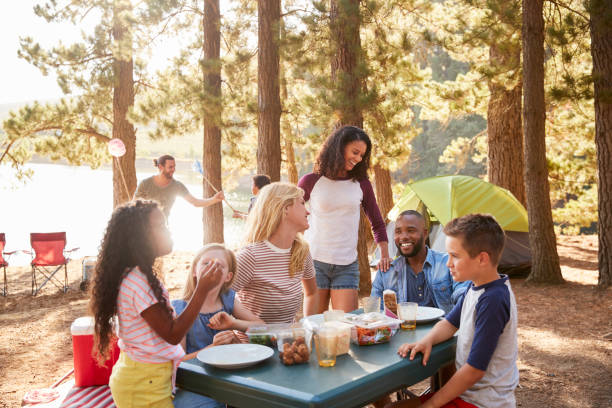 familia con campo de amigos por el lago en excursiones de aventura en el bosque - plato de comida fotos fotografías e imágenes de stock