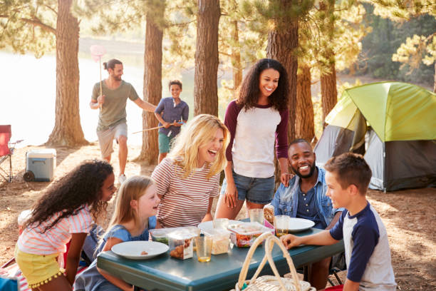 familia con campo de amigos por el lago en excursiones de aventura en el bosque - camping family vacations eating fotografías e imágenes de stock