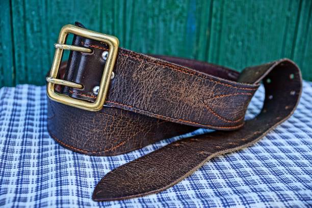 istock Brown retro leather belt at the green wall 966220892