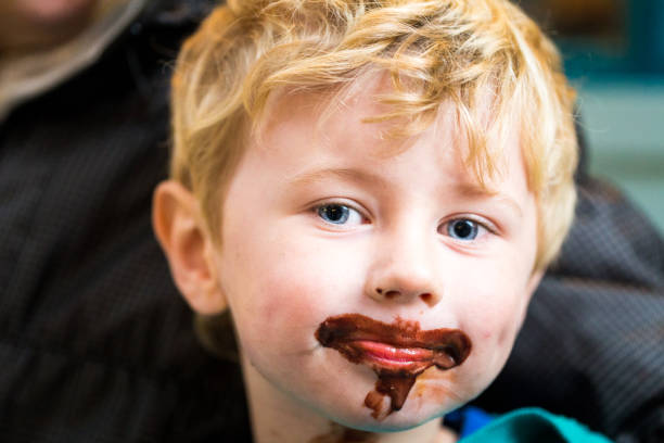 bambino con gelato al cioccolato spalmato sul viso - child chocolate ice cream human mouth foto e immagini stock