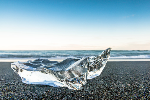 Clear washed up ice shape at a volcanic beach in Iceland. Beach near the Jokulsarlon glacier lagoon.