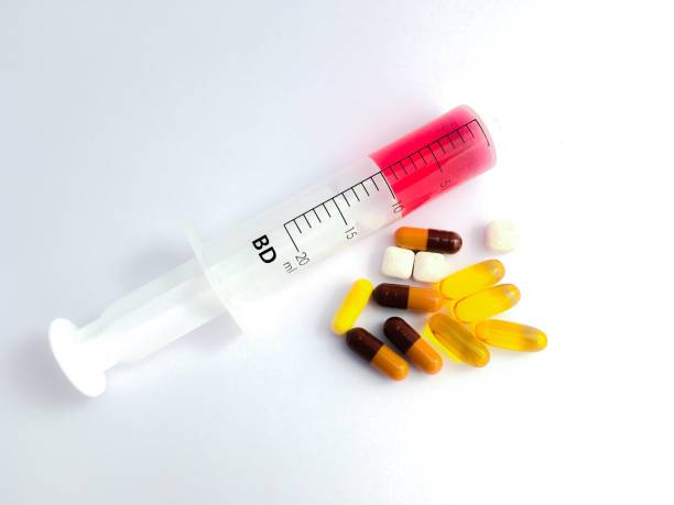 istock Medicine syringe and different pills. 966229044