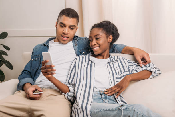 istock couple sitting with smartphones 966234446