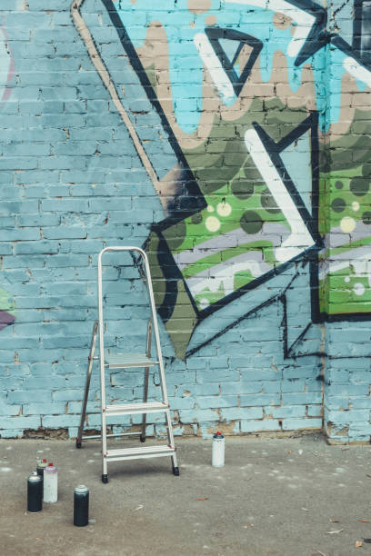 istock cans with spray paint and ladder near colorful graffiti on wall 966235594