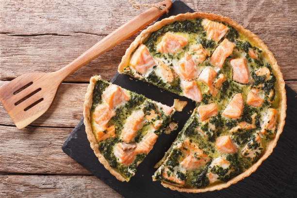 istock Sliced Quiche with salmon, spinach and cream close-up. horizontal top view 966236706