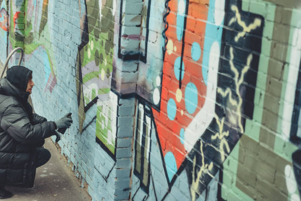 istock man painting colorful graffiti on wall 966239774