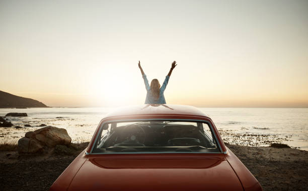 Shot of a young woman enjoying a road trip along the coast