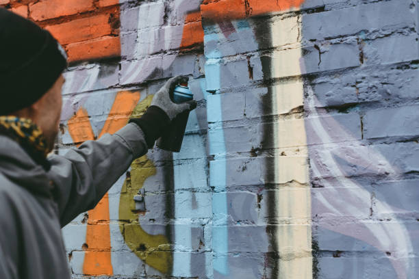 istock man painting colorful graffiti on wall 966247648