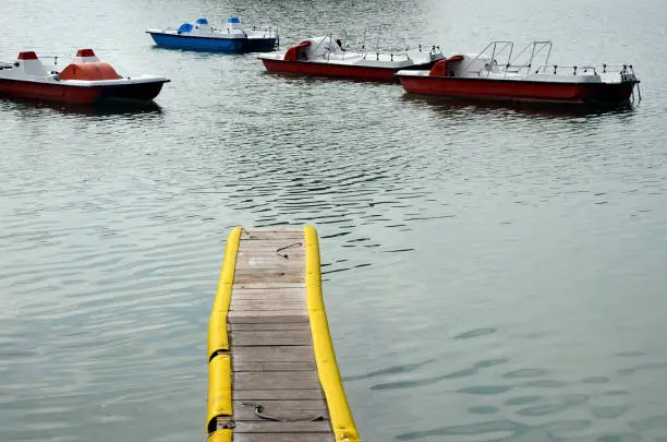 Pedalo, pedalboats and yellow pontoon on Annecy lake, France