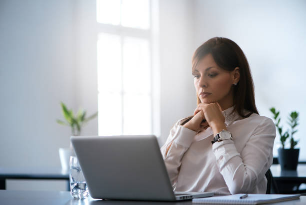 istock Young woman in the office working with a laptop 966249446