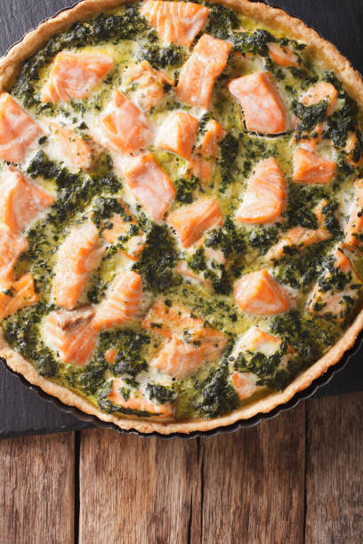 istock tart with red fish, spinach and herbs in baking dish close up on a table. vertical top view 966261078