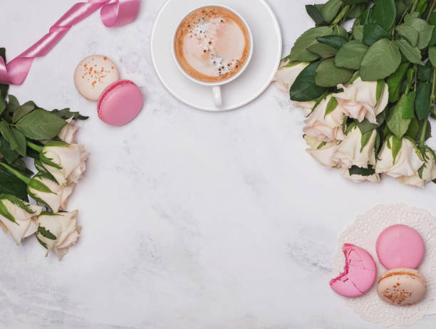 istock White roses, coffee and macarons on the marble background 966263376